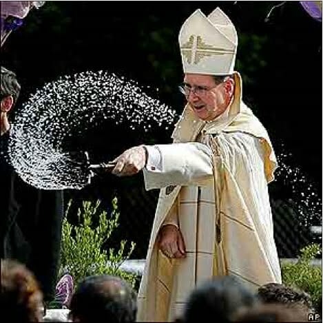 Padre benzendo o povo com água benta católica