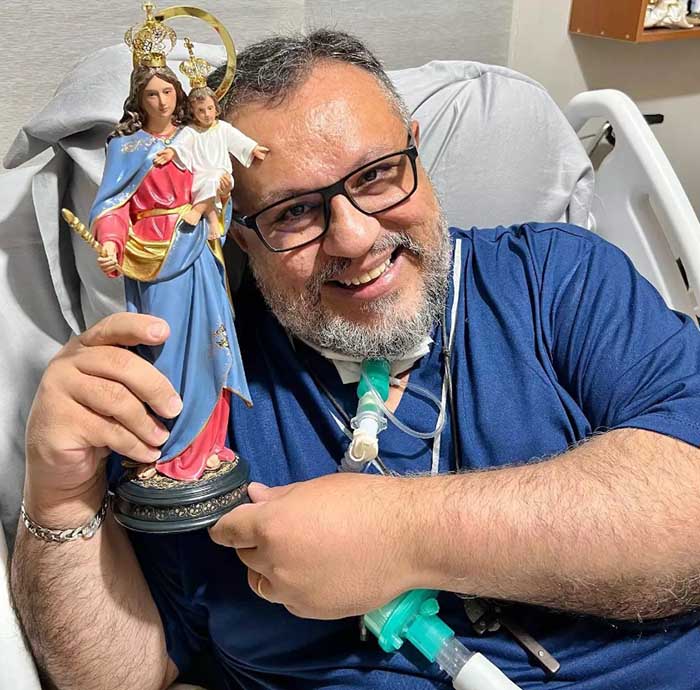Padre Márlon Múcio no hospital segurando a imagem da Santa da Igreja Católica